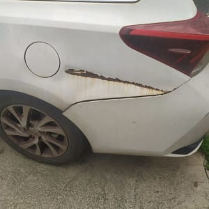 נזק לרכב בצד אחורי עם שריטות וחלודה