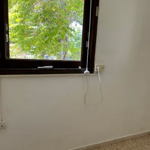 שקע חשמל ליד חלון עם כבל תלוי
