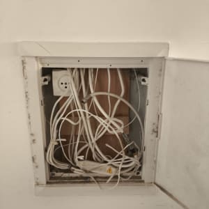 ארון תקשורת עם כבלים חשופים בקיר