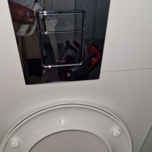 לחצן הדחה מעל אסלה בחדר אמבטיה