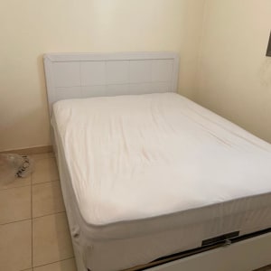 מיטה זוגית עם מזרן לבן בחדר ריק