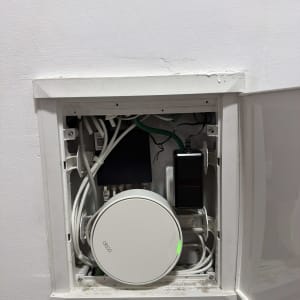 ארון תקשורת ביתי שקוע בקיר ובו יחידת MESH של Deco וכבלי רשת