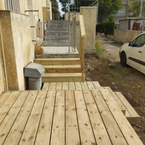 דק עץ חדש ליד מדרגות בטון