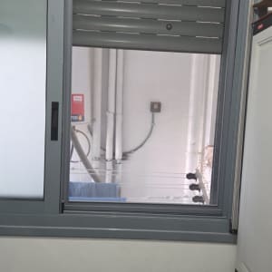 חלון אלומיניום עם תריסים ומסגרת אפורה