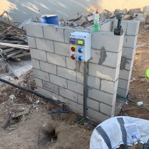 לוח חשמל על קיר בלוקים עם כבלים וכלים