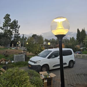 מנורת רחוב מוארת ליד רכב חונה