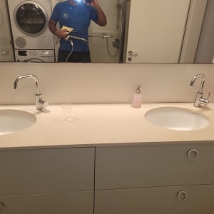 אדם מחזיק צינור מים בחדר אמבטיה