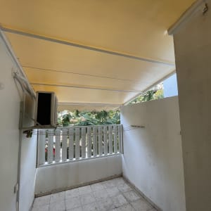 מרפסת עם סוכך צהוב ומזגן על הקיר