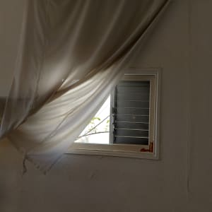 חלון עם זכוכית ותריסים פתוחים למחצה