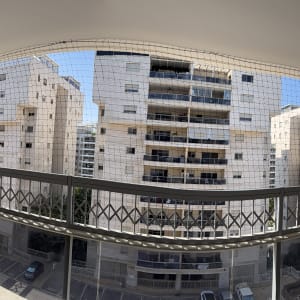 מרפסת עם רשת נגד יונים בבניין מגורים