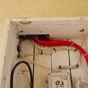 ארון תקשורת עם כבלים אדומים ולבנים, קופסת חיבורים