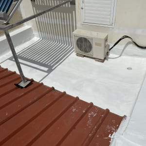 גג עם ציפוי לבן, קולטי שמש ומזגן