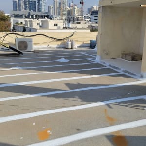 קווים לבנים של איטום על גג בטון