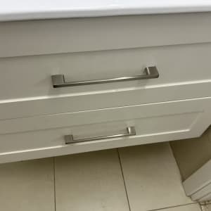 ידיות מתכת על מגירות לבנות במטבח