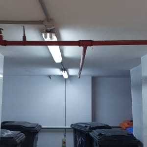 תאורת פלורסנט מותקנת על תקרה עם צינורות חשמל