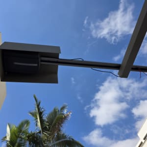 שער חשמלי עם שמיים כחולים ועצים ברקע