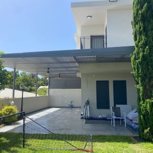 פרגולה מאלומיניום עם גג פתוח ומאווררים תלויים