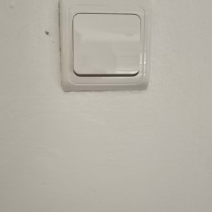 מתג חשמל לבן על קיר לבן