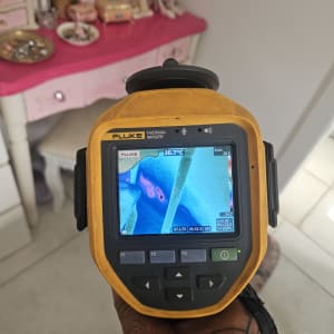 מצלמה תרמית מציגה תמונה על רקע שולחן איפור ורוד