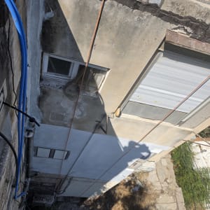 עבודות איטום וצביעה של חזית בניין בגובה באמצעות חבלים