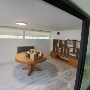 חדר עם שולחן עגול וארון מדפים מעץ