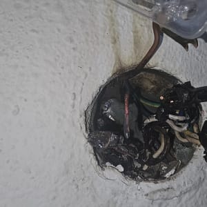 חוטי חשמל חשופים בקיר עם חיבורים חשמליים