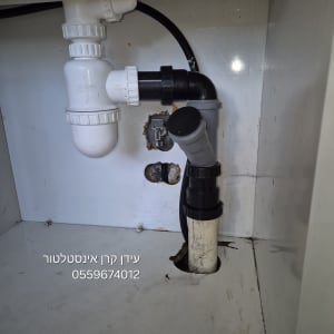 צנרת פלסטיק לבנה ושחורה מתחת לכיור