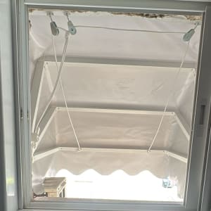 סוכך לבן עם מסגרת מתכת ומנגנון חבלים