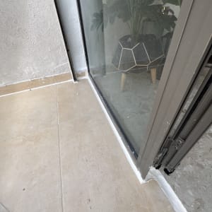 חלון זכוכית עם איטום לבן על הרצפה