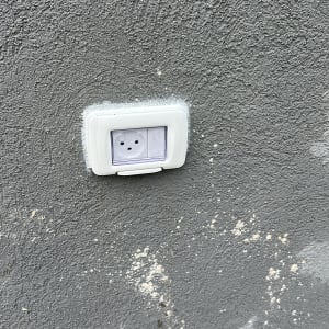 שקע חשמלי מותקן על קיר אפור