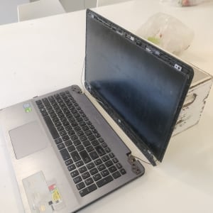 מחשב נייד עם מסך שבור על שולחן לבן