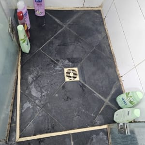 מקלחת עם בקבוקי שמפו על הרצפה