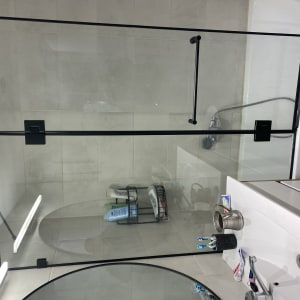 מקלחון זכוכית עם מדף מוצרים וסבונים