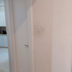 דלת לבנה עם ידית מתכת על קיר לבן