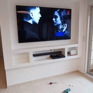 טלוויזיה תלויה על קיר גבס עם מדפים מובנים