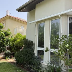 בית עם גינה ותריסים חיצוניים