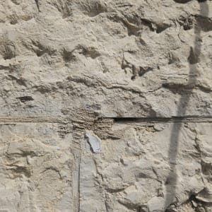 קיר אבן עם סדק אופקי וצללים