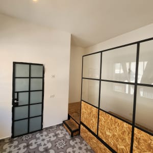 קיר לבן עם דלת זכוכית ומנורה תלויה