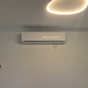 מזגן מותקן על קיר בחדר עם תאורה
