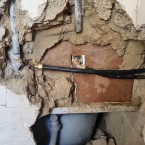 צינורות מים חשופים בקיר שבור