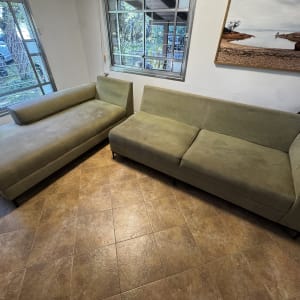 ספות ירוקות בחדר עם חלונות גדולים