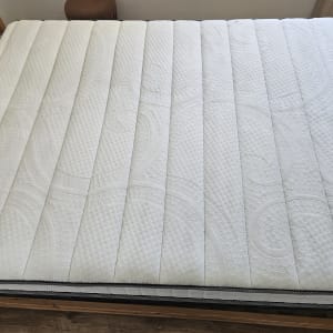 מזרן לבן עם דוגמה גיאומטרית על מיטה