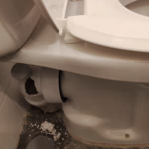 אסלה עם חיבורי צנרת ופתח בקיר