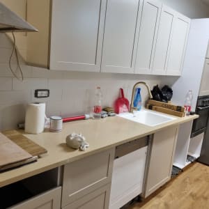 מטבח עם ארונות לבנים, כיור וברז זהב