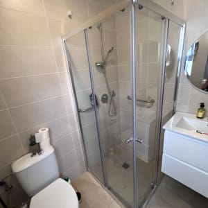 מקלחון זכוכית עם ראש מקלחת ומדף קטן