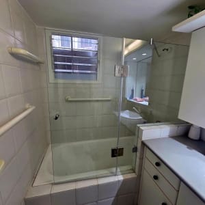 מקלחת עם דלת זכוכית וחלון קטן