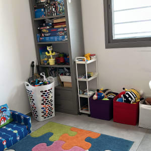מדפים עם משחקים, סל צעצועים, שטיח צבעוני