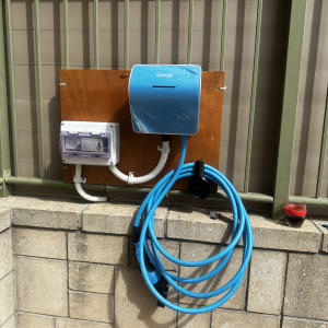 עמדת טעינה חשמלית עם כבל כחול על קיר