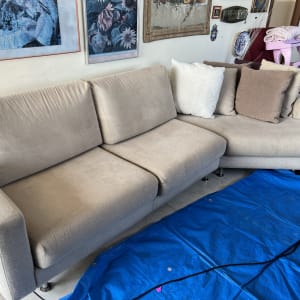 ספה בהירה עם כריות על יריעת פלסטיק כחולה