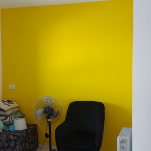 קיר צבוע בצהוב עם חפצים בחדר